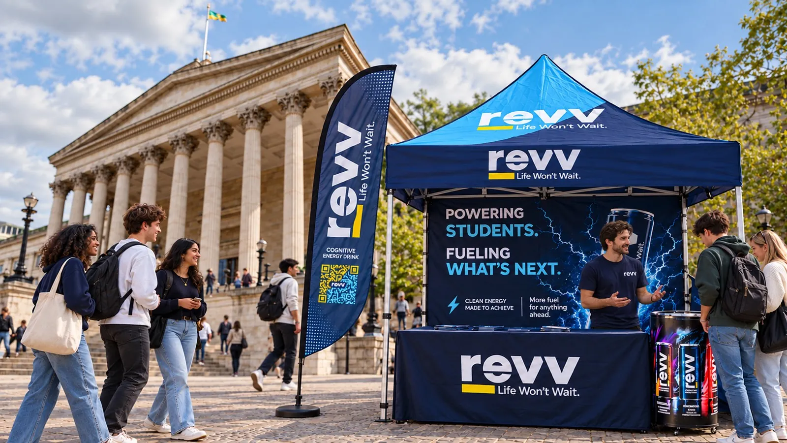 A revv stand and flag outside the UCL Portico, with students stopping to talk to the team