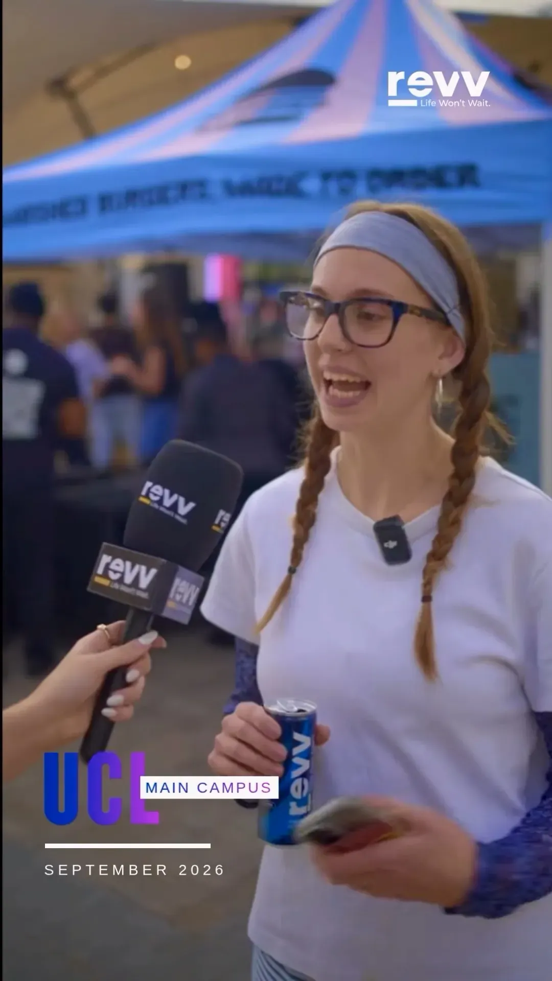 A student in glasses holding a can of revv Cognitive while being interviewed.